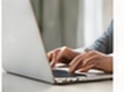 Hands typing on a laptop keyboard
